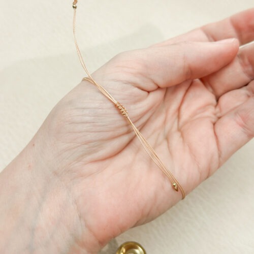 Dieses Bild zeigt dir, wie du dein Edelstein Armband ganz einfach selbst kürzen kannst. Mit etwas Gefühl, einer Schere und einem Feuerzeug passt du dein Makramee-Armband perfekt an dein Handgelenk an. Ideal für alle, die es lieber etwas enger oder lockerer mögen. Eine einfache DIY-Lösung ohne Rückversand oder Neu-Knüpfen – liebevoll erklärt und mit natürlichen Materialien umgesetzt.