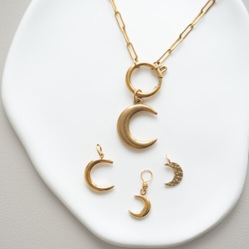 Midnight Magic – Mond Charms 🌙✨ Der Mond steht für das weibliche Prinzip, für Empfänglichkeit, Intuition und Emotionen. Er spiegelt das zyklische Wesen des Lebens wider – Wachsen, Vergehen und Neubeginn – genau wie die Mondphasen am nächtlichen Himmel. Als Hüterin des inneren Wissens und der verborgenen Kräfte lädt dich diese Kollektion dazu ein, dich liebevoll mit deinen eigenen Rhythmen zu verbinden. Wähle deinen Mond-Charm als ganz persönlichen, visuellen Anker für deinen Alltag: Intuition & Gefühle: Der Mond verstärkt das Unbewusste und lädt dich ein, nach innen zu schauen. Er erinnert dich daran, dass auch das Verborgene und Leise seinen ganz eigenen Wert hat. Zyklen & Wandel: Wie der Mond sich wandelt, so darfst auch du dich verändern. Nichts bleibt gleich – und genau in diesem Vertrauen liegt deine wahre Kraft. Weiblichkeit & Sanftheit: Tief verbunden mit dem weiblichen Zyklus, steht der Mond für Hingabe, schöpferische Fruchtbarkeit und nährende, sanfte Energie. Schutz & Geborgenheit: In der Dunkelheit leuchtet der Mond als sanfter Wegweiser. Er schenkt dir Trost, tiefe Seelenruhe und eine sichere Verbindung zu deiner inneren Welt. Kombiniere diese liebevoll ausgewählten Symbole mit deinem handgemachten Edelstein Schmuck, um die zyklische Kraft der Natur spürbar bei dir zu tragen. ✨ 🕊️ Affirmation: „Ich erkenne, was ich loslassen darf – und finde zurück zu mir.“