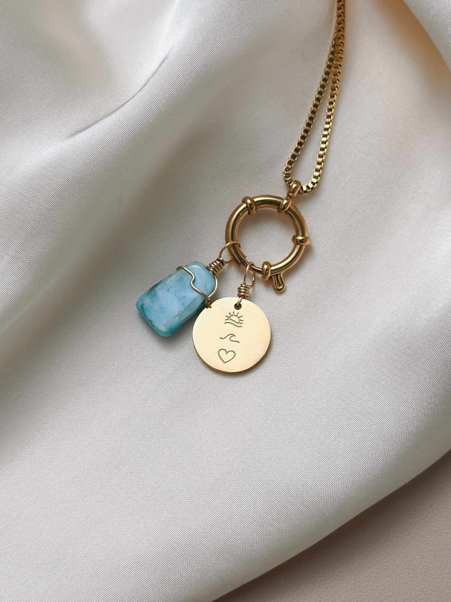 Meerweh 🌊 Meerweh ist die leise Sehnsucht nach dem Ozean – nach Weite, Freiheit und Licht. Es erinnert an den letzten Tag am Meer: den Wind auf der Haut, die Wellen, die dich umspielen, die Sonne, die langsam tiefer sinkt – und das Gefühl, ganz bei dir zu sein. Der Charm vereint Herz, Welle und Sonne – drei Symbole, die für das stehen, was dich trägt: Liebe. Fluss. Licht. Er erinnert dich daran, dass du nicht immer dort sein musst, wo dein Herz wohnt – aber du darfst es spüren. Jederzeit. ✨ Bedeutung von Meerweh: Herz: für alles, was du liebst – innen wie außen Welle: für Wandel, Bewegung und das Fließen des Lebens Sonne: für Licht, Wärme und das Erinnern an das, was war Sehnsucht & Weite: für Momente, in denen du dich nach dem Meer sehnst – und dich trotzdem verbunden fühlst Freiheit: für deine innere Küste, die du immer bei dir trägst 🕊️ Affirmation: „Ich trage das Meer in mir – frei, lichtvoll und voller Erinnerung.“ Details zum Schmuck Material: PVD-Vakuumbeschichtung 304 Edelstahl 14K Echtgold plattiert  Größe: 15 x 15 mm groß und mit einer stabilen Öse versehen. Der Anhänger passt zu deiner YOUR.line Kette Ein kleiner Begleiter mit großer Bedeutung – minimalistisch, zeitlos und voller Kraft. 🤍 Lieferumfang: nur Anhänger