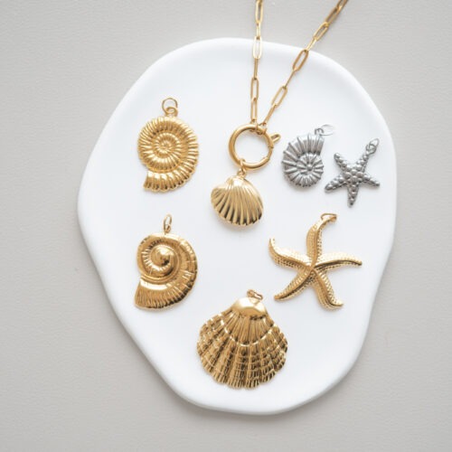 Soul of the Ocean - deine Begleiter für Tiefe & Urvertrauen 🌊 Das Meer ist der Ursprung allen Lebens und das kraftvollste Symbol für die Tiefe unserer Gefühle, für unendliche Weite und die beruhigende Kraft des ewigen Flusses. Genau wie die Wellen des Ozeans kommt und geht auch in unserem Leben alles in eigenen Rhythmen. Die Schätze des Meeres erinnern uns daran, uns dem Fluss des Lebens hinzugeben und darauf zu vertrauen, dass wir getragen werden. Wähle deinen Meeres-Charm als ganz persönlichen Anker für deine Seelenruhe: Muschel: Als schützendes Zuhause steht die Muschel für Geborgenheit, das Bewahren deiner inneren Schätze und die tiefe Kraft der Weiblichkeit. Sie erinnert dich daran, auf deine innere Stimme zu hören. Seestern: Ein funkelnder Stern des Meeresbodens. Der Seestern symbolisiert Regeneration, Erneuerung und die wunderbare Fähigkeit, sich selbst zu heilen und immer wieder neu zu entfalten. Ammonit: Diese Jahrmillionen alten Spiralen sind heilige Symbole für die Unendlichkeit, Evolution und die perfekte Ordnung der Natur. Sie schenken dir Erdung und helfen dir, zu deiner eigenen Mitte zu finden. Kombiniere diese sorgfältig ausgewählten Meeressymbole mit deinem handgemachten Edelstein Schmuck, um die beruhigende und klärende Energie des Ozeans spürbar bei dir zu tragen. 🐚✨