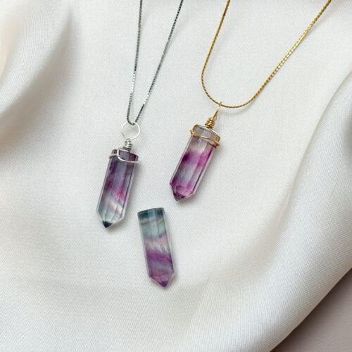 Fluorit – Der Edelstein der Klarheit und Leichtigkeit Ich erkenne, was wichtig ist – klar, leicht und frei. Fluorit bringt Struktur in dein Gedankenchaos. Wie ein frischer Wind klärt er die innere Unruhe, ordnet das Durcheinander und schenkt dir geistige Klarheit. Wenn du dich überfordert fühlst oder zu viel auf einmal denkst, hilft er dir, Prioritäten zu setzen und die Dinge mit Leichtigkeit zu betrachten. Fluorit unterstützt dabei, Entscheidungen klarer zu treffen – mit Kopf, Herz und Humor. Gleichzeitig öffnet er den Blick für neue Perspektiven und stärkt deine Intuition. ✨ Themen Fluorit Mental: Geistige Freiheit, Intuition, Überblick, Klarheit, Struktur, Ordnung, Konzentration, Humor, Leichtigkeit, Entschlossenheit, Perspektive erweitern, Gefühlsausdruck, Gefühle, Lebendigkeit, Neubeginn Körper: Nervensystem, Gelenke, Schleimhäute, Zähne, Haut Chakra: Drittes Auge, Solarplexus Planet: Merkur Element: Luft Sternzeichen: Wassermann, Fische, Skorpion, Löwe, Stier, Zwillinge 🗿 Mineralogische & historische Fakten: Fluorit ist ein farblich vielfältiger Kristall, der in fast allen Regenbogenfarben vorkommt. Aufgrund seiner Klarheit wurde er früher zur Herstellung von Linsen verwendet – auch spirituell gilt er als „Brille der Seele“. In China und Ägypten wurde Fluorit zur Meditation und zur Reinigung des Geistes eingesetzt. Er wurde oft als Schutzstein gegen äußere Einflüsse getragen, insbesondere bei mentaler Überforderung. Sein Name stammt vom lateinischen fluere – „fließen“ – was sinnbildlich für seine reinigende und ordnende Wirkung steht. ☝🏼 Details zum Edelstein Schmuck Naturstein – daher kann der Edelstein von den Bildern abweichen. Größe mit Öse 30 x 8 mm Öse: Kupferdraht 18k vergoldet / Kupferdraht dauerhaft emailliert in Silber mit Liebe und Intuition handgemacht 💜 Lieferumfang: Nur Anhänger