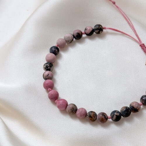 Rhodonit – Der Edelstein der Vergebung und inneren Stärke 💗🔥 Ich lasse alte Verletzungen los und finde Kraft in meinem Herzen. Rhodonit ist ein Stein für tiefe emotionale Heilung und bewusste Transformation. Er begleitet dich, wenn alte Verletzungen, Schuldgefühle oder innere Spannungen gesehen und gewandelt werden möchten. Seine Energie wirkt zugleich sanft und kraftvoll: herzöffnend, stabilisierend und stärkend. Rhodonit hilft dir, dich selbst mit Mitgefühl zu betrachten, Verantwortung für deine Gefühle zu übernehmen und wieder Vertrauen in deine eigene innere Kraft zu finden. Besonders in Zeiten des Neubeginns unterstützt er dabei, emotionale Altlasten loszulassen, klare Grenzen zu setzen und aus Erfahrungen zu wachsen. Er verbindet Herz und Handlungskraft und erinnert dich daran, dass Vergebung kein Vergessen ist, sondern ein Akt der Selbstfürsorge. ✨ Themen Rhodonit Mental: Transformation, Neubeginn, Selbstwert, innere Kraft, Kontrolle, Herzöffnung, Vergebung, Verständnis, Kommunikation Chakra: Wurzelchakra, Herzchakra Planet: Mars Element: Erde, Feuer Sternzeichen: Widder, Stier 🗿 Mineralogische & historische Fakten Rhodonit ist ein manganhaltiges Silikat (MnSiO₃) und leicht an seiner rosa bis rosaroten Farbe mit dunklen Adern aus Manganoxid zu erkennen. Diese Zeichnung macht jeden Stein einzigartig. Der Name leitet sich vom griechischen rhodon ab, was „Rose“ bedeutet. Historisch wurde Rhodonit bereits im antiken Griechenland und später besonders in Russland geschätzt. Dort galt er als Schutzstein für Reisende und als Symbol für Versöhnung und seelische Stärke. In der russischen Kultur wurde Rhodonit häufig verschenkt, um Frieden, Mitgefühl und emotionale Balance zu fördern.