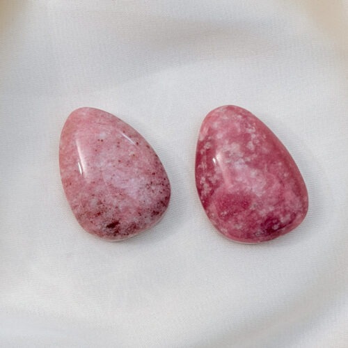 Thulit – Der Edelstein der Herzensöffnung und Lebensfreude 🌸🔥 Ich öffne mein Herz, gehe mutig voran und vertraue meiner Lebenskraft. Thulit ist ein Stein des Mutes und der Herzensenergie. Er bringt Bewegung ins Gefühl, stärkt Selbstvertrauen und lädt dazu ein, das Leben aktiv zu gestalten. Seine warme, rosafarbene Ausstrahlung verbindet Herzöffnung mit Tatkraft und unterstützt dich dabei, neue Projekte mit Freude und innerer Klarheit zu beginnen. Er hilft, Herausforderungen anzunehmen, ohne dich selbst zu überfordern. Thulit wirkt belebend, kreativ und stärkend, besonders dann, wenn dein Herz mehr Raum braucht, um sich frei, lebendig und authentisch auszudrücken. ✨ Themen Thulit Mental: Herzöffnung, Mut, Selbstvertrauen, Lebensfreude, Kreativität, neue Projekte beginnen, Herausforderungen annehmen, innere Stärke, Stressmanagement, emotionale Aktivierung Chakra: Herzchakra Planet: Mars Element: Feuer Sternzeichen: Widder 🗿 Mineralogische & historische Fakten Thulit ist eine rosafarbene Varietät des Minerals Zoisit. Seine charakteristische Farbe entsteht durch Mangangehalt im Kristallgitter. Der Stein wurde erstmals in Norwegen entdeckt und nach der sagenumwobenen Insel Thule benannt, die in der Antike als Symbol für Ursprünglichkeit, Lebenskraft und den hohen Norden galt. ✨ Details  Die Anhänger sind ca. 30 x 25 mm groß Jeder Stein wird bewusst ausgewählt und naturbelassen verarbeitet. Durch die gebohrte Form lassen sich die Alltagsanker direkt an einem zarten Band tragen oder individuell kombinieren. Diese Anhänger sind keine Unikate im klassischen Sinn, sondern bewusst einfach gehaltene Begleiter. Sie stehen nicht im Vordergrund, sondern wirken still im Hintergrund. Als Edelstein für zwischendurch, als Geschenk oder als persönlicher Alltagsanker.