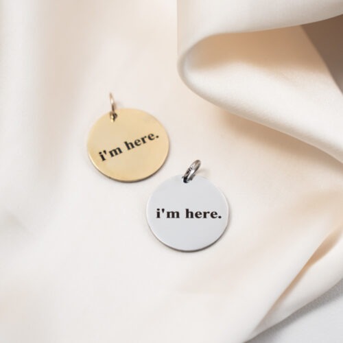 I’m here. Minimalistischer Statement Anhänger aus Edelstahl „I’m here.“ Zwei Worte. Eine klare Haltung. Dieser runde Anhänger steht für Präsenz. Für Ankommen im Moment. Für das bewusste Hier-Sein – unabhängig davon, was außen gerade laut ist. Er erinnert dich daran, deinen Raum einzunehmen, dich zu zeigen und nicht kleiner zu machen, als du bist. Der Affirmation Anhänger ist minimalistisch gestaltet und passt zu schlichten Ketten, zu Layering-Looks oder als ruhiger Akzent im Alltag. Sein reduziertes Design macht ihn zeitlos und vielseitig kombinierbar. Gefertigt aus hochwertigem Edelstahl, ist er robust, langlebig und angenehm zu tragen. Ob als tägliche Erinnerung an deine Präsenz oder als Geschenk mit Bedeutung – dieser Schmuck mit Botschaft begleitet dich leise, aber klar. Ein Statement ohne Lautstärke. Nur: Ich bin hier.