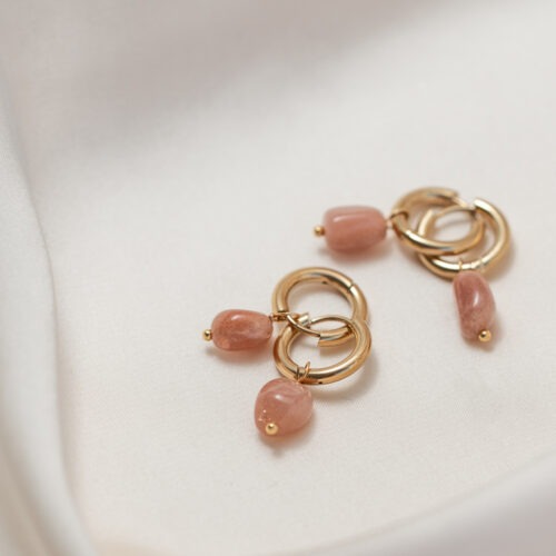 Rosa Mondstein – Der Edelstein der Gefühle und Zyklen Ich bin mit meinem Körper und meinem Rhythmus im Einklang. Rosa Mondstein ist ein besonders sanfter und tief weiblicher Begleiter, der dich in Kontakt mit deinen Gefühlen, deinem Zyklus und deiner inneren Weisheit bringt. Er schenkt dir Empfindungstiefe, öffnet dein Herz für emotionale Prozesse und stärkt deine Intuition. In bewegten Zeiten bringt er Balance, Erdung und ein Gefühl von innerer Ruhe. Seine zarte Schwingung unterstützt dich dabei, dich selbst besser zu spüren – körperlich wie emotional. Wenn du dich mit der Natur, dem Kosmos oder deinem eigenen Rhythmus verbinden möchtest, ist Rosa Mondstein der perfekte Begleiter. ✨ Themen Rosa Mondstein Mental: Perspektive erweitern, Gefühlsausdruck, Balance, Erdung, Empfindungstiefe, Gefühle, Medialität, innere Ruhe, Naturverbundenheit, Spiritualität Chakra: Sakralchakra, Kronenchakra Element: Wasser, Kosmos Sternzeichen: Krebs, Fische, Stier, Steinbock, Skorpion 🗿 Mineralogische & historische Fakten: Rosa Mondstein gehört zur Familie der Feldspate und zeigt einen sanften Schimmer, der als Adulareszenz bezeichnet wird – ein zartes Leuchten, das über seine Oberfläche zu gleiten scheint. Diese Wirkung entsteht durch das Wechselspiel von Licht und den feinen Lamellen im Inneren des Steins. Bereits in der Antike wurde Mondstein als heilig angesehen und mit dem Mond und der weiblichen Energie in Verbindung gebracht. Besonders in Indien galt er als Stein der Liebe und Fruchtbarkeit. Der rosa Farbton entsteht durch den Einschluss von verschiedenen Mineralien, z. B. Feldspat mit Mangan. Wusstest du schon? Man sagt, der Rosa Mondstein bringe Klarheit in emotionale Prozesse und fördere den Zugang zu Träumen und intuitivem Wissen – besonders rund um den Vollmond. ☝🏼 Details zum Edelstein Schmuck ø Creolen 15mm // Länge ca. 30 mm Naturstein – daher weicht der Edelstein von den Bildern abweichen. Edelstahl 18k vergoldet mit Liebe und Intuition für dich handgemacht Da ich den Schmuck für dich anfertige dienen die Bilder als Beispiel. Die Edelsteine unterscheiden sich in Farbe und Form. Aber ich kann dir sagen, dass alle wunderschön und mit dem Auge fürs Detail ausgesucht werden